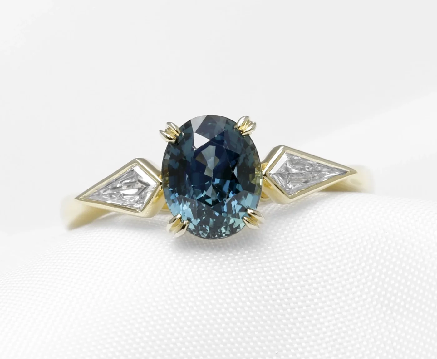 Bespoke Commission: Contemporary Style Engagement Ring in 18 ct Yellow Gold with Kite Diamonds and an Oval Mixed Cut Teal Sapphire Completed 2024