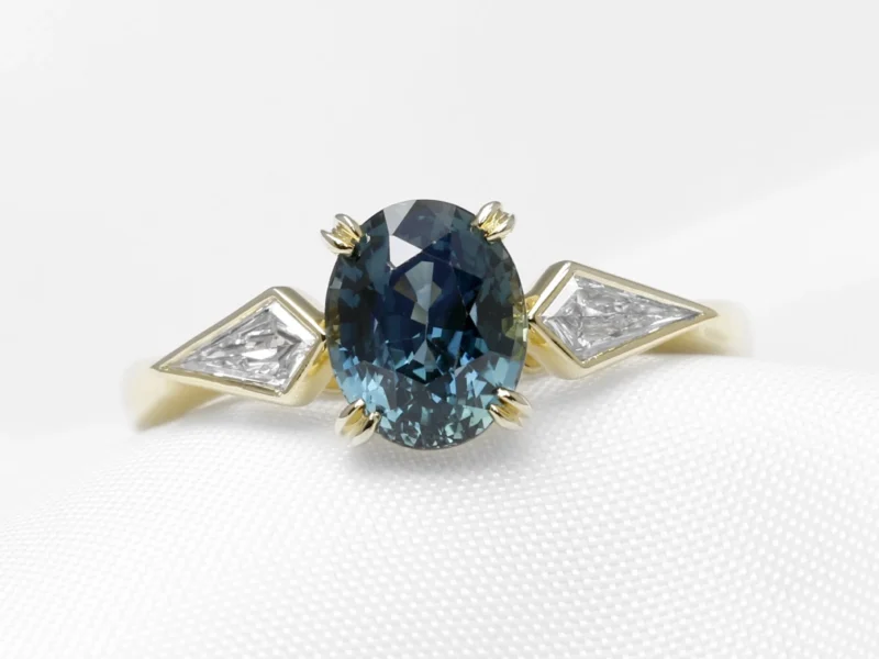 Bespoke Commission: Contemporary Style Engagement Ring in 18 ct Yellow Gold with Kite Diamonds and an Oval Mixed Cut Teal Sapphire Completed 2024