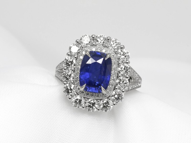 blue sapphire cluster ring, set with a central 3.81ct oblong faceted blue sapphire, surrounded by two halos of diamonds.