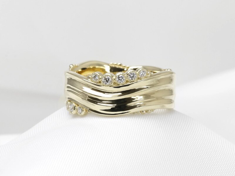 Wave band with diamonds in yellow gold