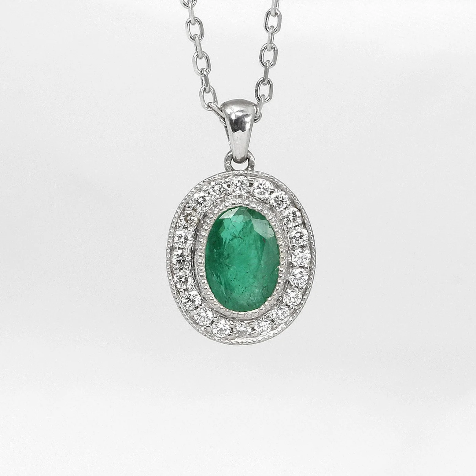 Emerald and Diamond Halo Pendant in White Gold