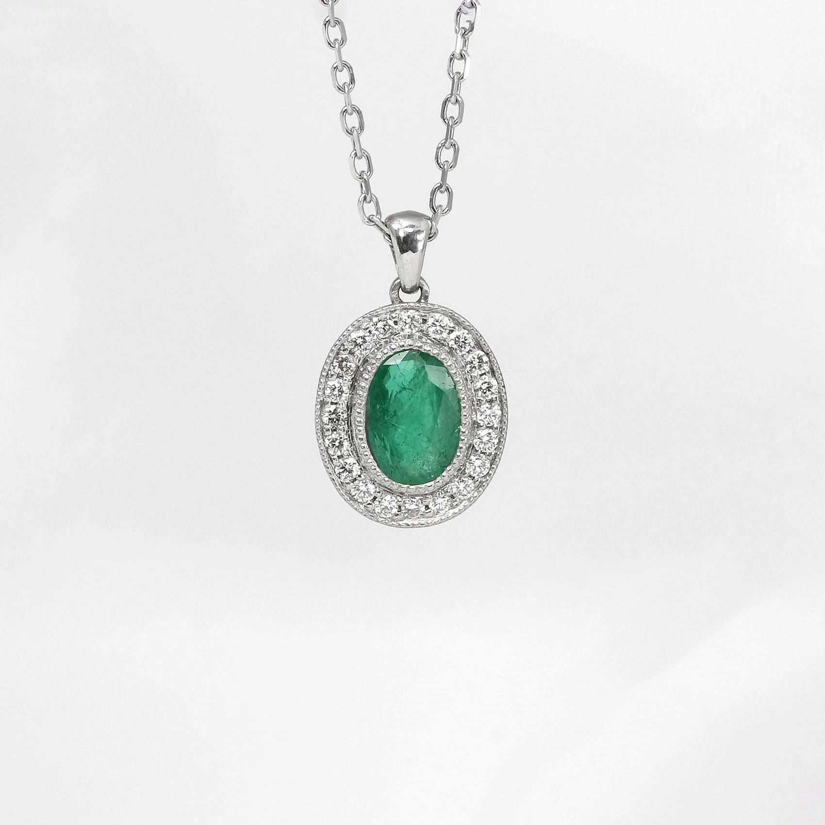 Emerald and Diamond Halo Pendant in White Gold