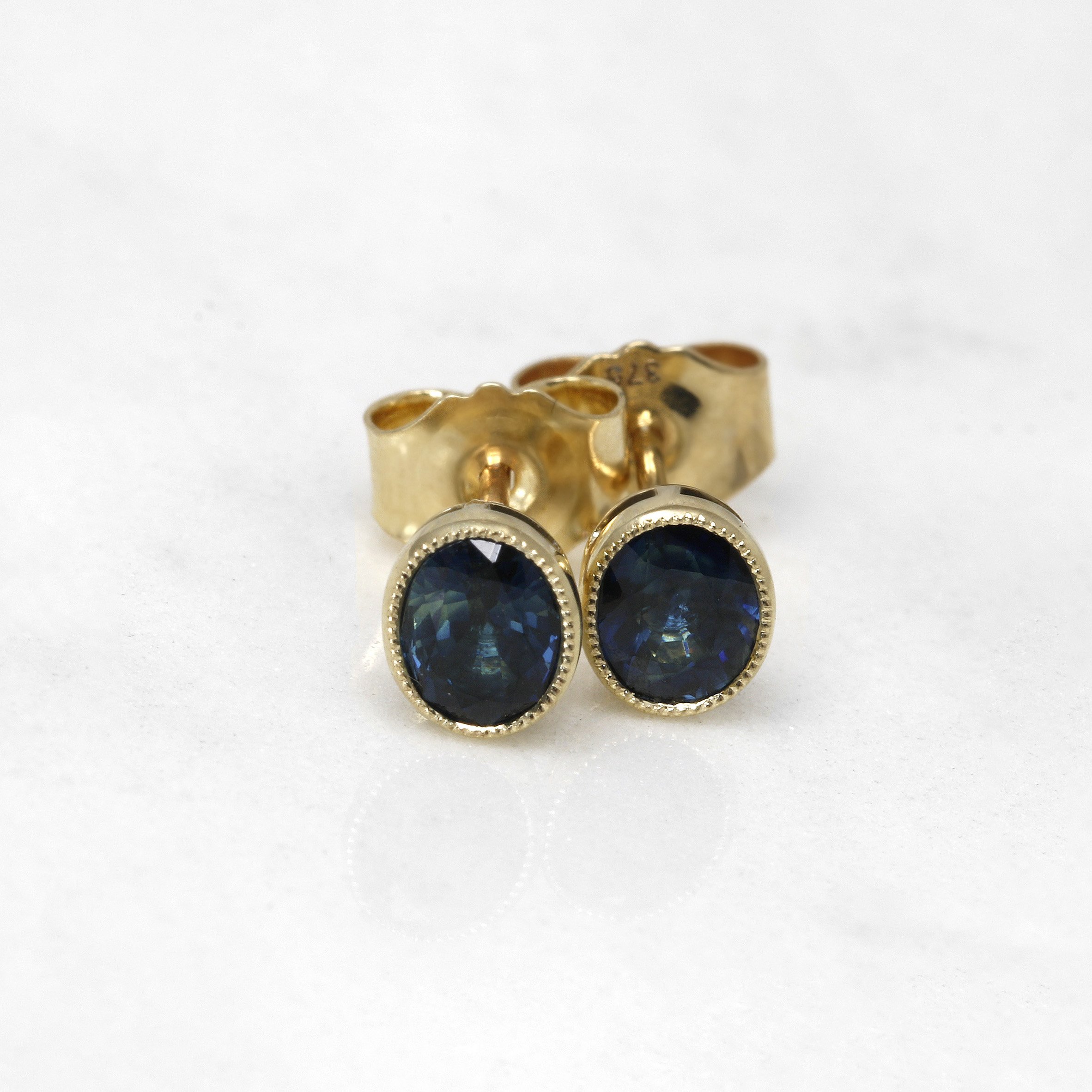 Oval Teal Sapphire Stud Earrings in Yellow Gold