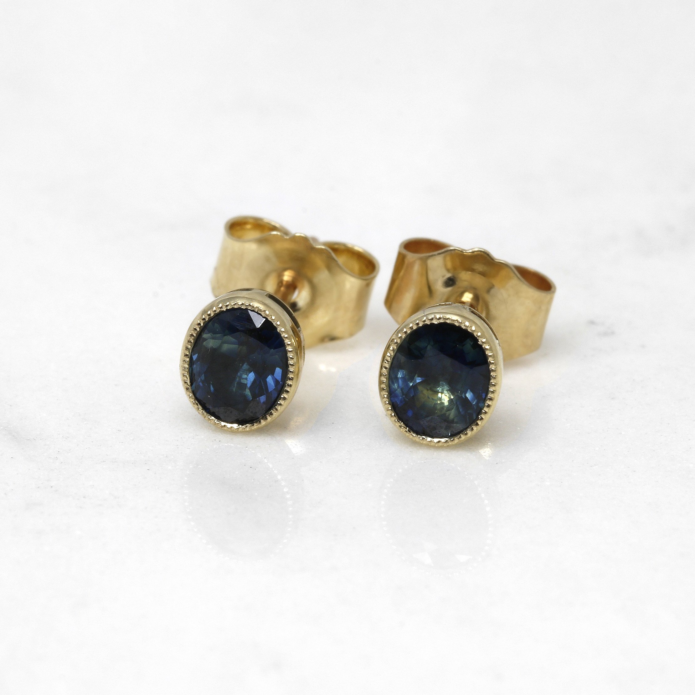Oval Teal Sapphire Stud Earrings in Yellow Gold