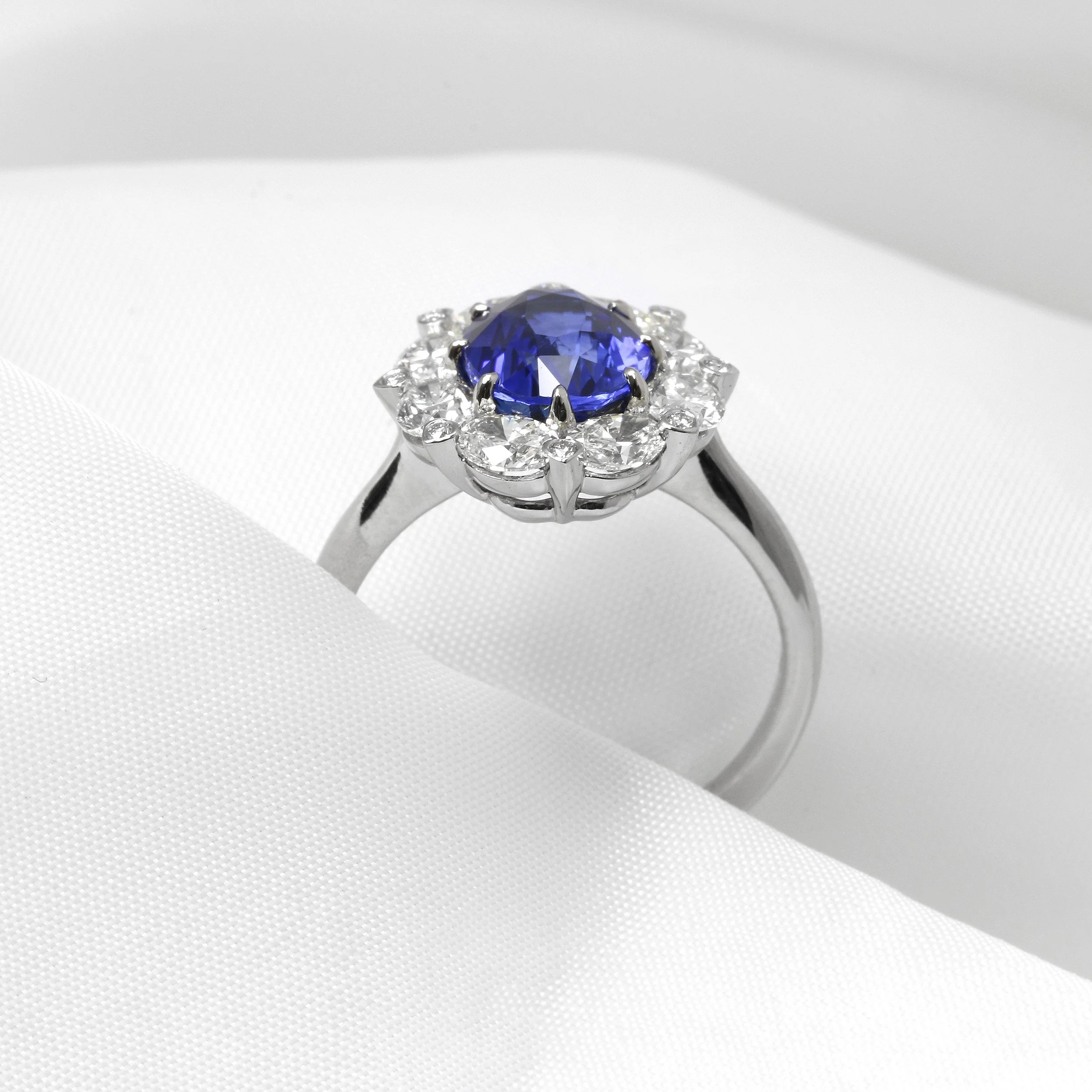 Oval Sapphire and Diamond Bordered Cluster Ring in Platinum